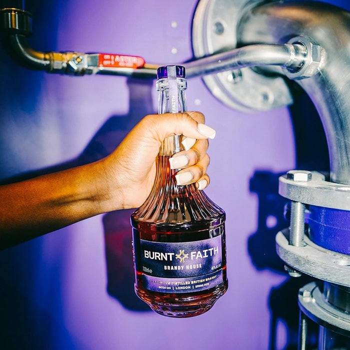 Person Holding A Bottle Of Burnt Faith Brandy