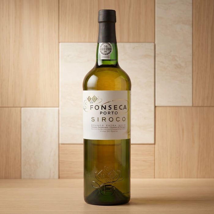 Bottle of Fonseca Porto Siroco wine on a wooden surface with a wooden paneled background