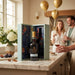 Bottle of Graham's 40 year old port in a decorative box on a kitchen counter with people in the background.