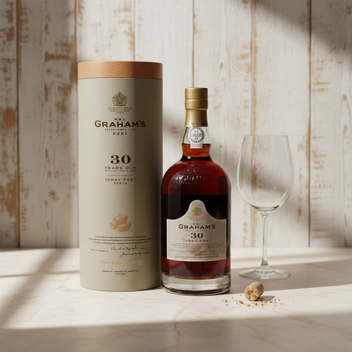 Graham's 30-year-old port bottle and packaging on a wooden surface with a glass.
