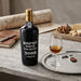 Kopke White Colheita 2008 Porto bottle with a glass of wine on a wooden table.