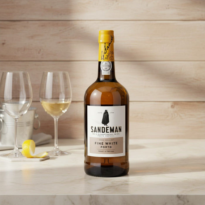 Bottle of Sandeman Fine White Port with two glasses on a wooden surface