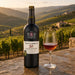 A bottle of Taylor's 30 Year Old Port stands on a stone surface beside a filled wine glass, with a scenic vineyard landscape in the background at sunset.
