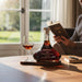 Kopke 10-year-old tawny port bottle with a glass of wine on a table, person reading a book in the background