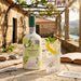 Bottle of Graham's Blend No.5 White Port with a glass of port and lemon garnish on a stone patio.