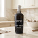 Kopke Fine White Porto bottle on a kitchen counter with a bowl and branches in the background.