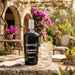 Kopke Lagrima White Porto bottle with a glass of water and lemon on a table outdoors.